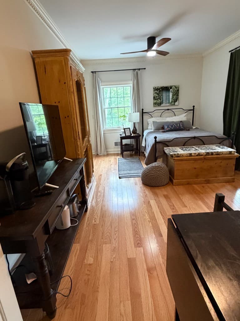 Guest bedroom with in-room coffee station and forest views