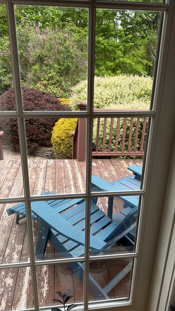 Private wooded deck with Adirondack seating overlooking the garden
